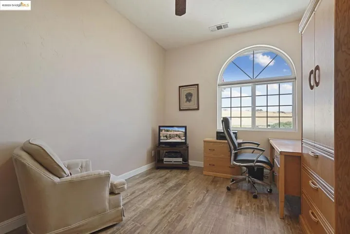 Office area featuring dark wood finished floors and a ceiling fan
