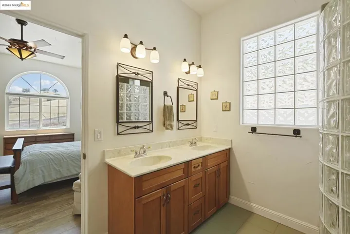 Bathroom with double vanity, light tile patterned flooring, and ensuite bathroom