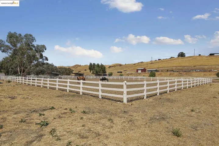 View of yard with an outdoor riding arena and a rural view