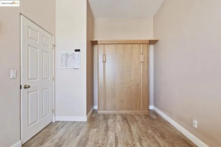 Unfurnished bedroom with light wood finished floors and baseboards