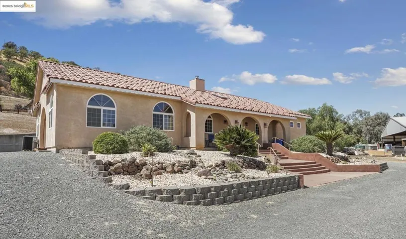 Mediterranean / spanish-style house with stucco siding, a chimney, a tile roof, and a porch