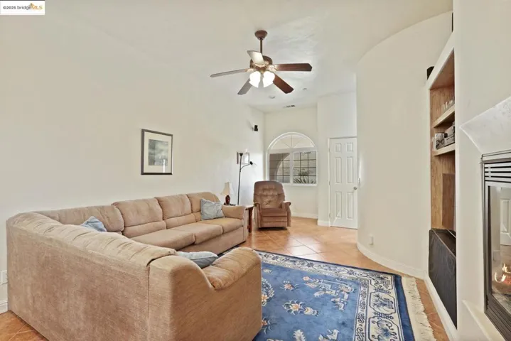 Living room with light tile patterned floors and ceiling fan