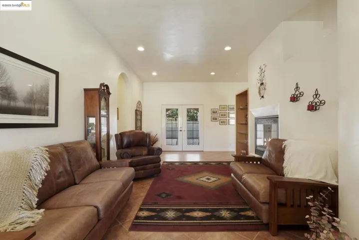 Tiled living area featuring french doors, recessed lighting, and arched walkways