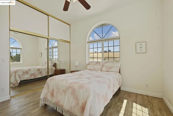 Bedroom with a closet, wood finished floors, and ceiling fan