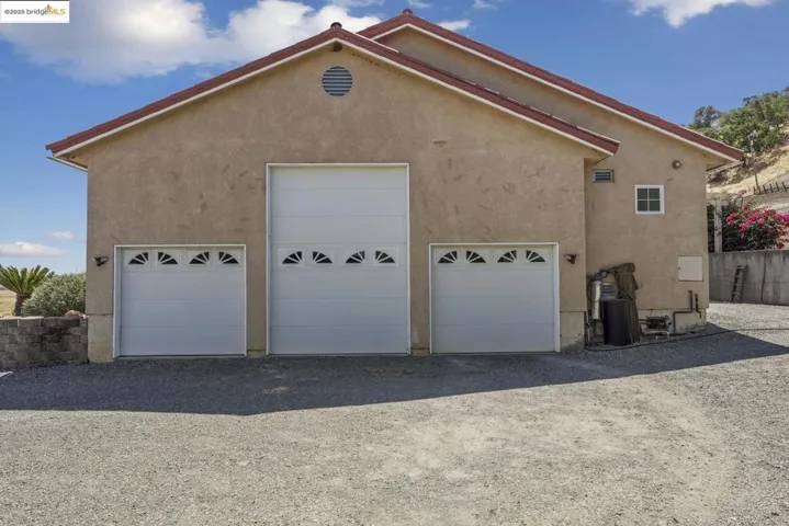 View of side of property featuring stucco siding and an outbuilding