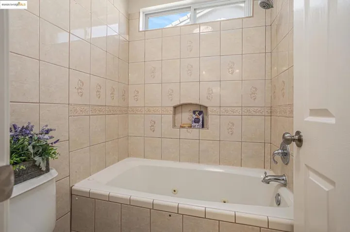 Bathroom with a combined bath / shower with jetted tub and tile walls