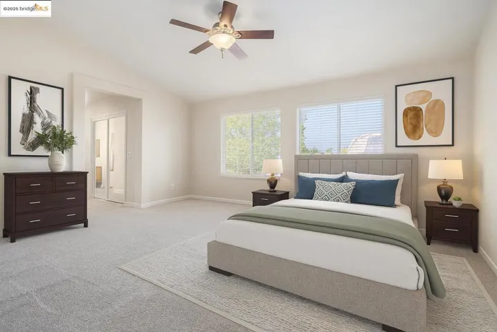 Bedroom featuring light carpet, ceiling fan, and lofted ceiling