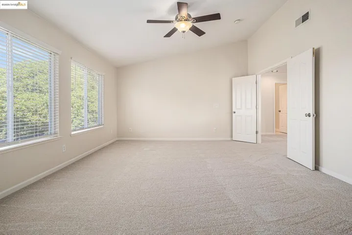 Bedroom Suite with double doors, with vaulted ceiling, light carpet, ceiling fan, and new vinyl blinds