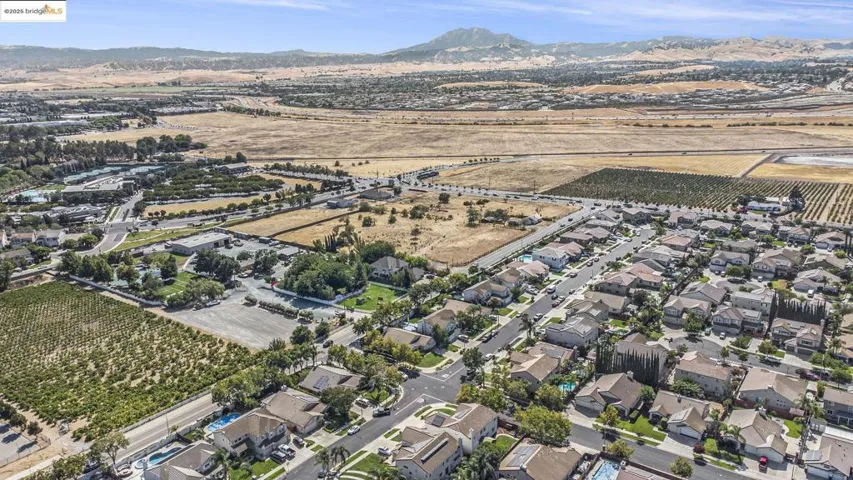 Aerial view of property and surrounding area with rural landscape and a mountainous background. Easy access to the bypass/hwy 4, shopping center, and sports club.