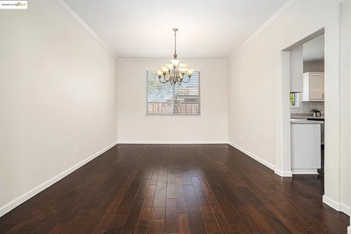 Dining area featuring crown molding, engineered hardwood flooring, and chandelier.