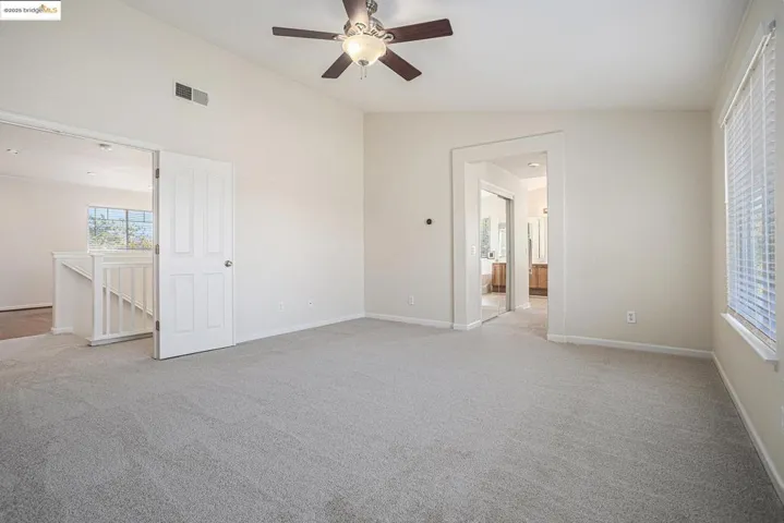 Vaulted ceiling, new light colored carpet, ceiling fan, and an ensuite bath