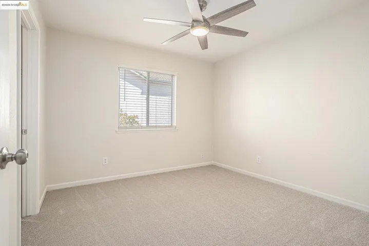 Bedroom offers walk-in closet with organizer, light colored carpet, ceiling fan and new vinyl window covering.