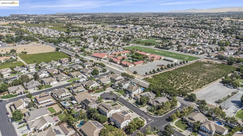 Aerial overview of property's location with a mountain backdrop and nearby elementary and high school.