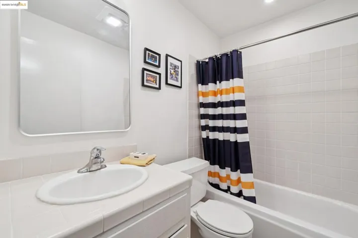 Bathroom with shower / bath combination with curtain and vanity