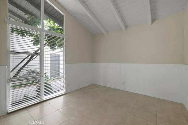 Secondary bedroom with high ceilings and floor to ceiling windows.