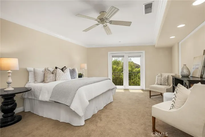 This soothing primary bedroom has a romantic Juliette balcony