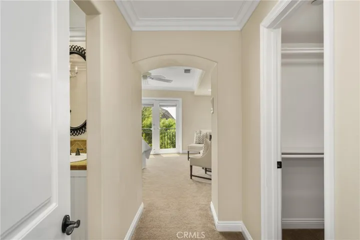 Entering the second primary suite on the lower level from a private hallway. A full bath is on the left and a walk-in closet on the right.