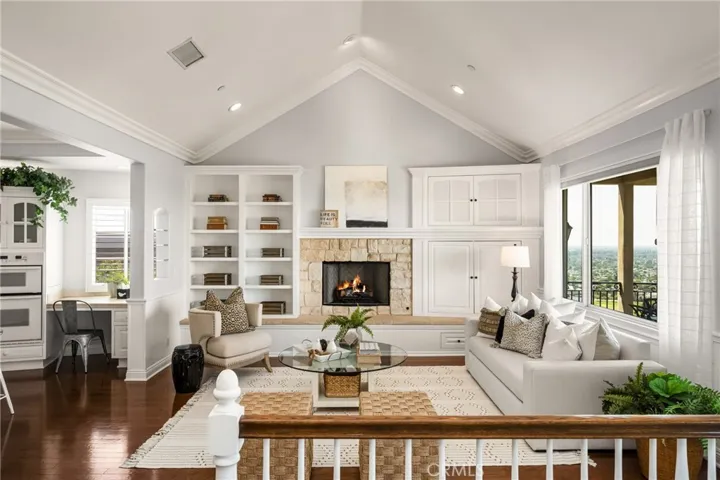 Custom built-in shelving & cabinetry flank the raised stone fireplace with mantle.