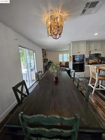 Dining space featuring a chandelier, dark wood-style floors, and a textured ceiling