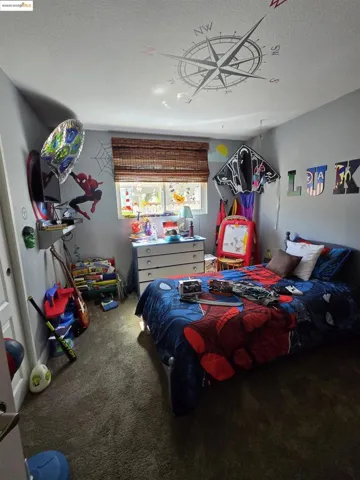 Bedroom with a textured ceiling and carpet