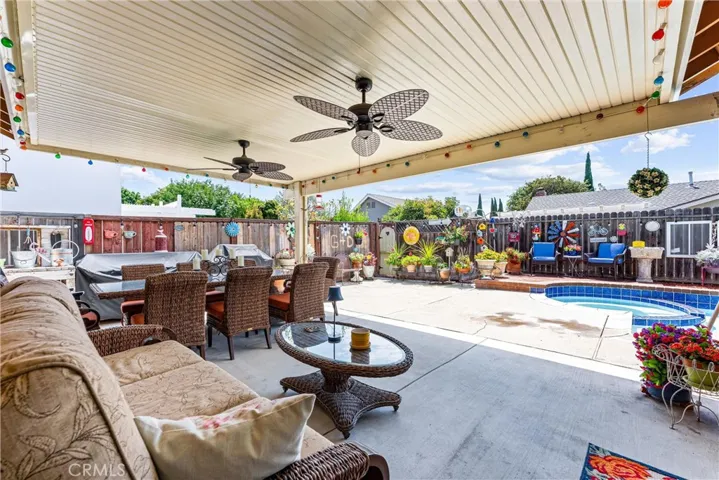 Patio with a ceiling fan that looks out to the pool