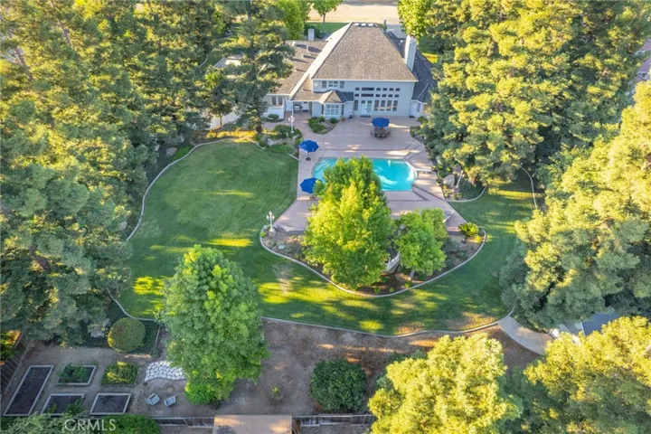 Overview of property facing north, displaying garden area, redwood trees surrounding the pool and gazebo area, and the back of the home