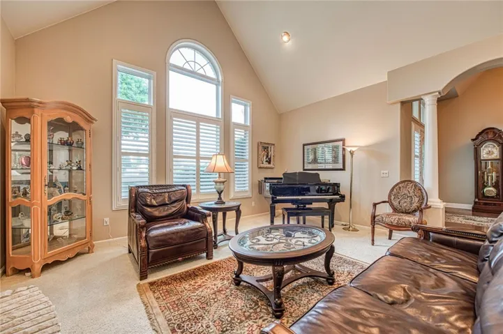 Formal living room displaying vaulted ceilings and a view of foyer