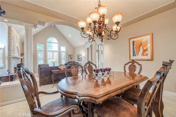 Formal dining room displaying custom chandelier and view of formal living room