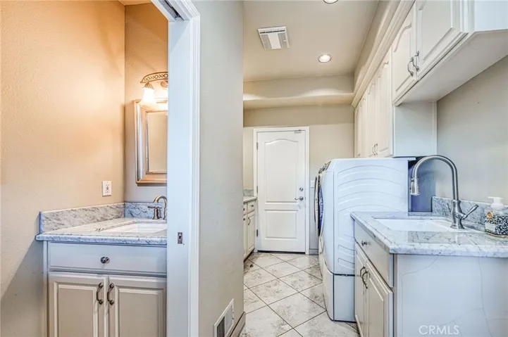 Laundryroom with accompanying powder room. Direct access from garage, and backyard pool area