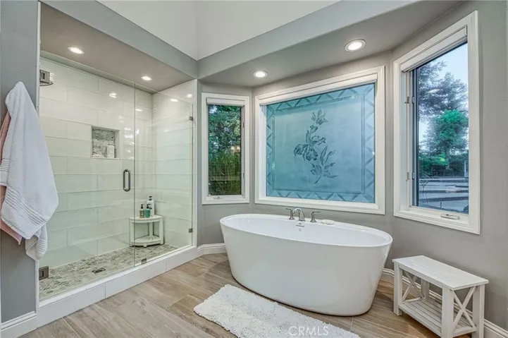 Primary en-suite bathroom bathtub and separate tiled walk-ion shower