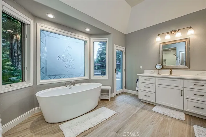 Primary en-suite bathroom soaking tub, bay window, and quartz countertops