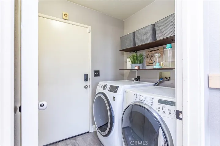 Convenient laundry room with shelving, there is a keypad lock on the garage fire door (pictured here) as well as a spacious under the stairs closet for extra storage.