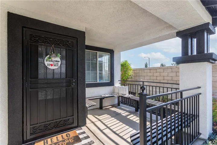 North facing front patio with benches for seating, security screen door and attractive front door with decorative glass window.