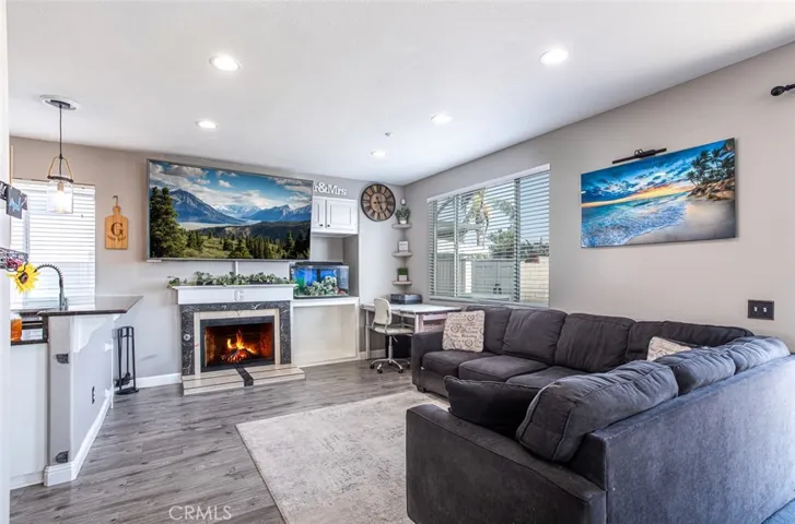 Family room with attractive granite fireplace, built-ins, wood laminate flooring and granite breakfast counter.
