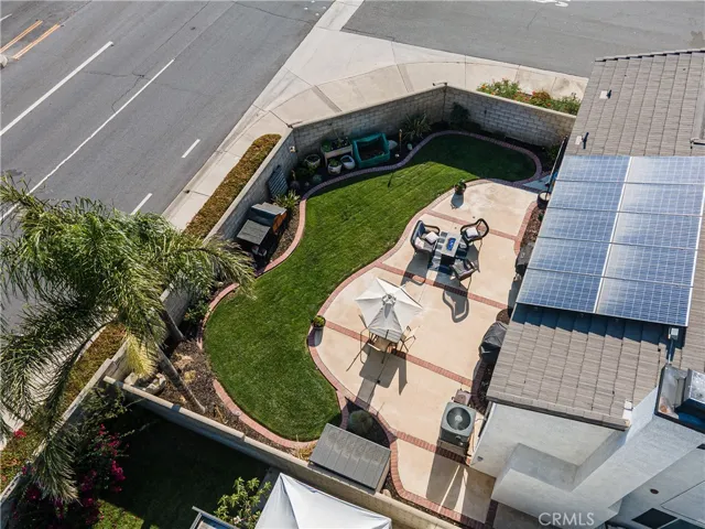 Aerial photo of the professionally landscaped backyard with brick pavers, fresh mulch, and lush, green lawn.