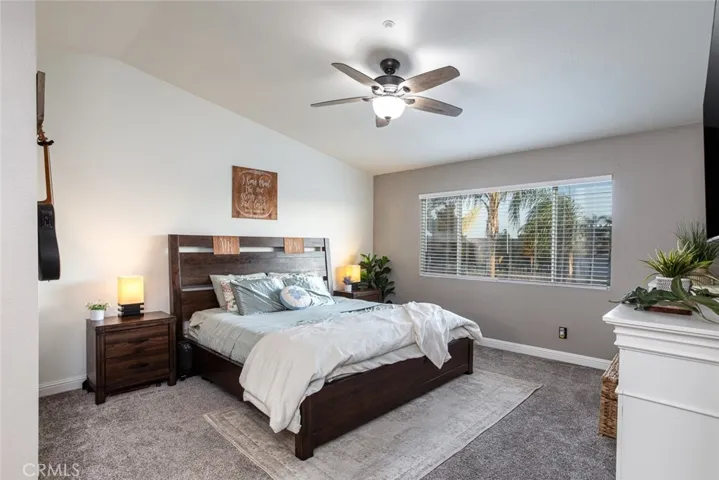 Attractive master bedroom with newer carpet, wide baseboards, and energy saving ceiling fan.