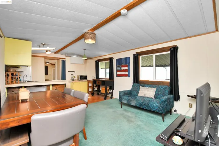 Carpeted living area featuring lofted ceiling