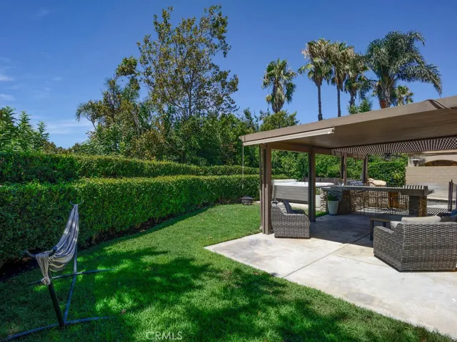Covered patio with drop down shades and grassy sideyard