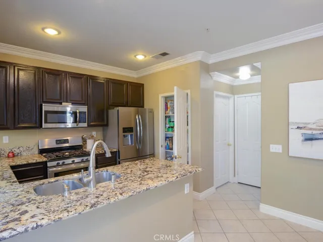 Kitchen with view of pantry and door that leads to interior laundry room