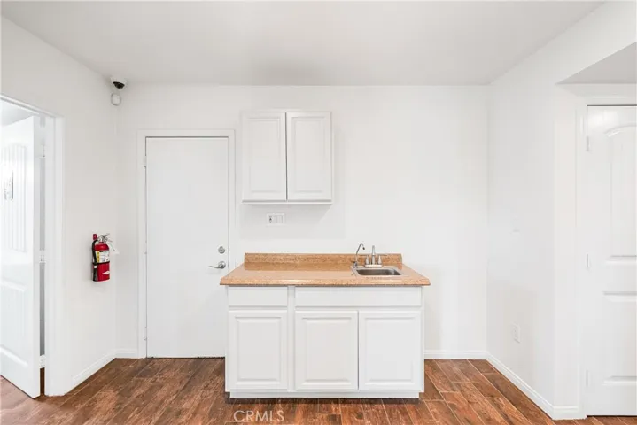 kitchenet showing back door and opening to bathroom