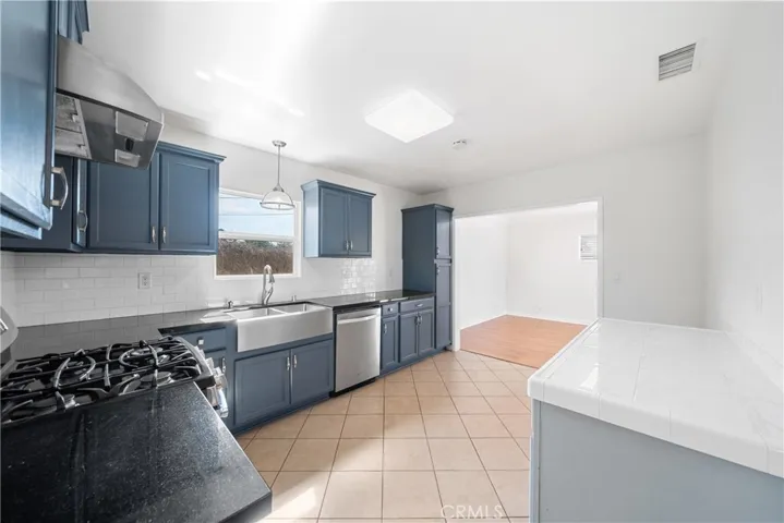 Kitchen from living room upgraded granite countertops, deep farmhouse sink, upgraded tile backsplash! tile flooring!