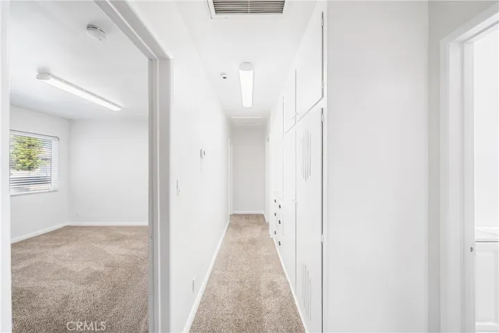 hallway entrance on left to bedroom 1 and 1st bathroom on right