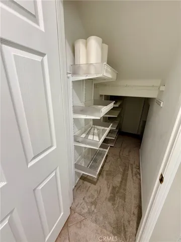 Under stairs closet has custom storage.