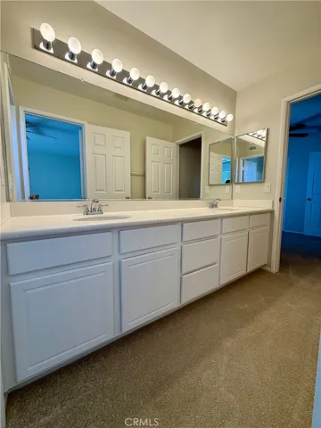 Secondary bathroom with dual vanities.