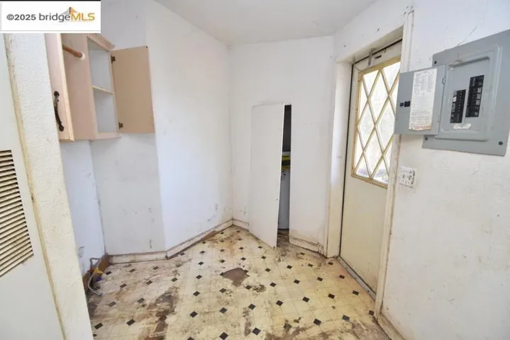 Doorway featuring tile patterned floors, electric panel, and a heating unit