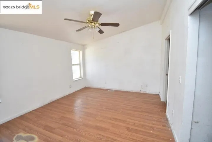 Unfurnished room with light wood finished floors and a ceiling fan