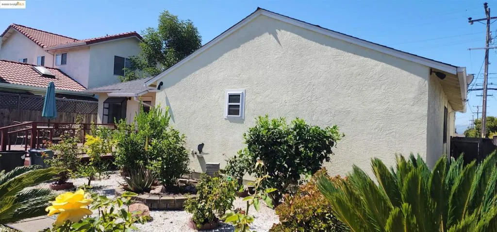 Rear view of house featuring stucco siding and a deck