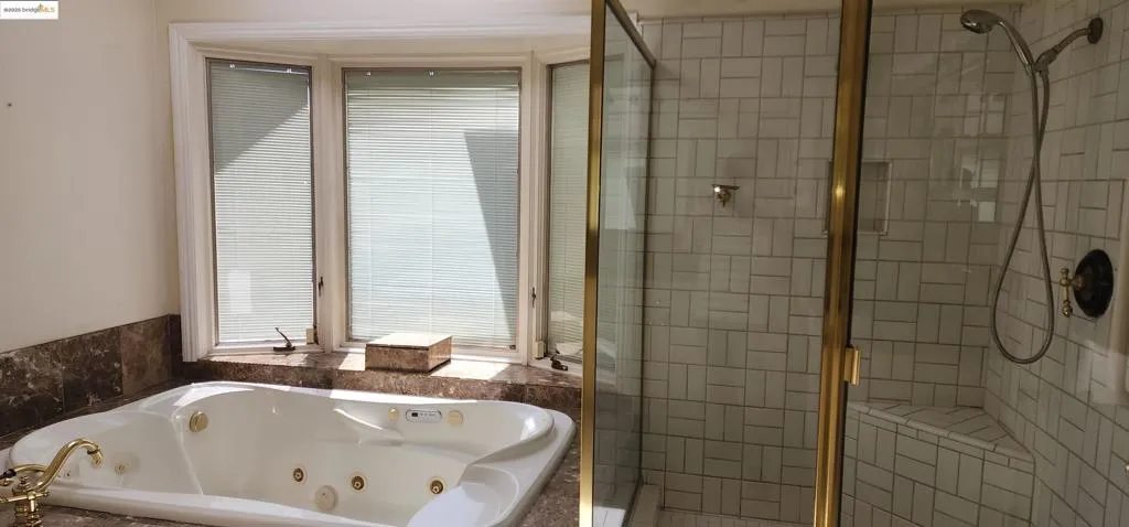Bathroom with a stall shower and a jetted tub