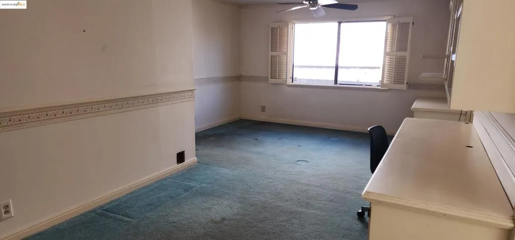 Unfurnished dining area with dark carpet and ceiling fan
