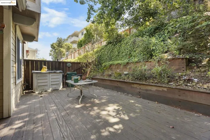 Wooden terrace with a fenced backyard
